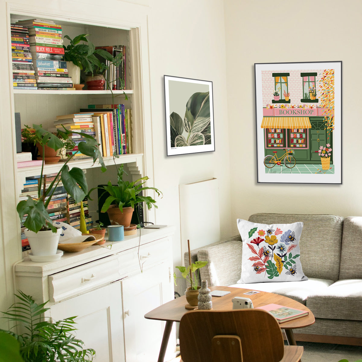 Living Room scene with Artwork of a Bookshop, Houseplant and Bee Cushion all designed by Illustrator Studio Peers